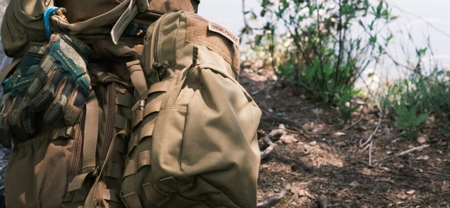 a backpack sitting on the ground next to a tree