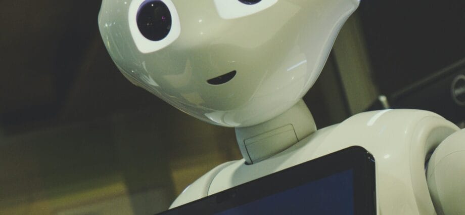 white robot toy holding black tablet